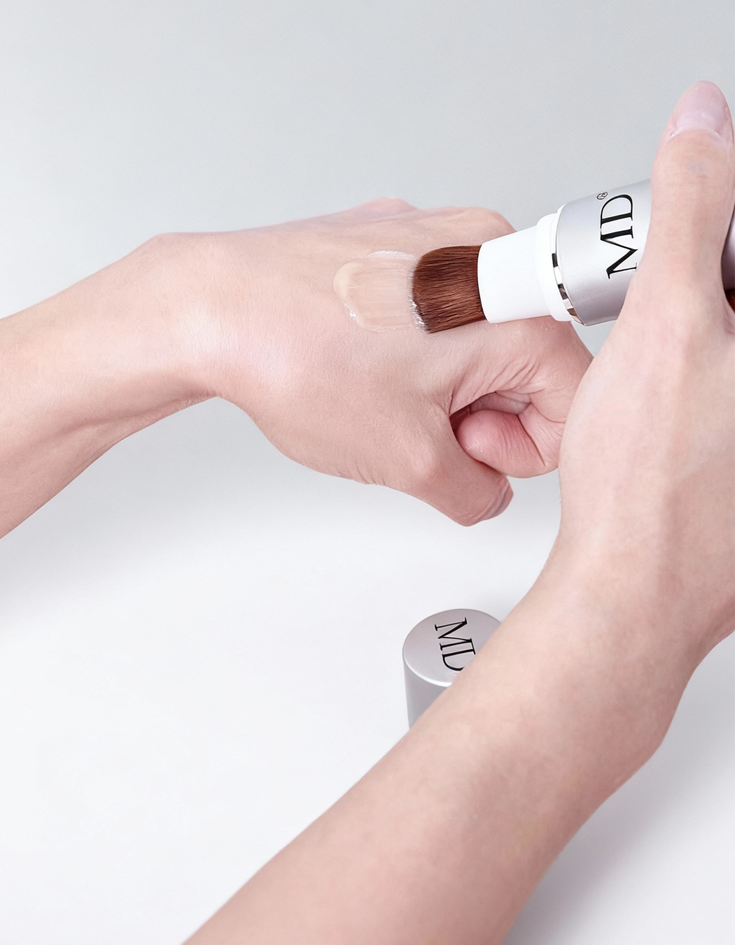 Close-up hand application of MD Follicle Energizer, showcasing its transparent, ultra-hydrating texture as the serum glides onto the scalp.